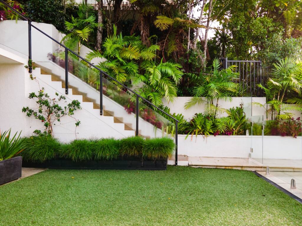 a white house with a green lawn and stairs